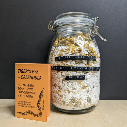 A glass mason jar of white bath soak with a black label that reads: 
