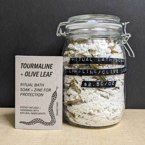 A glass mason jar of white bath soak with a black label that reads: 
