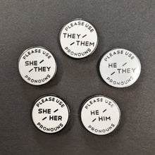 Load image into Gallery viewer, Five round white enamel pins with black text on a black background. Going clockwise the pins read:
PLEASE USE THEY/THEM PRONOUNS
PLEASE USE HE/THEY PRONOUNS
PLEASE USE HE/HIM PRONOUNS
PLEASE USE SHE/HER PRONOUNS
PLEASE USE SHE/THEY PRONOUNS 

Sold at Coyote Supply Co a BIPOC and LGBTQIA+ owned zero waste witch store in Reno Nevada